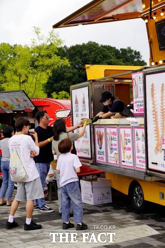 경기도 내 한 지역축제를 방문한 관람객들이 경기도주식회사가 제공한 다회용기에 담긴 음식을 푸드트럭 상인으로부터 건네 받고 있다. /경기도주식회사
