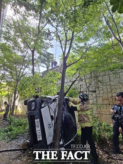 공주소방서 구급대원들이 25일 오전 10시 13분쯤 충남 공주시 유구읍 유구아파트 뒷길에서 1t 트럭 한대가 SUV와 충돌 후 옹벽 아래로 추락한 현장에서 수습하고 있다. /공주소방서