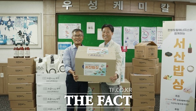 한화토탈에너지스 관계자가 고객사 우성케미칼 박병욱 대표이사(왼쪽)에게 서산지역 농수특산물을 전달하고 기념촬영을 하고 있다. /한화토탈에너지스