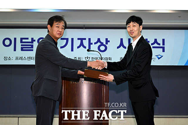 한국기자협회 이달의 기자상을 받은 <더팩트>의 남윤호 기자(오른쪽)가 26일 서울 프레스센터에서 열린 시상식에서 정재웅 <더팩트> 편집국장에게 상을 수여받고 있다.