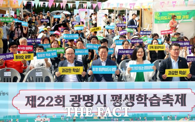 박승원 광명시장(앞줄 왼쪽 2번째)와 김남희 더불어민주당 국회의원(3번째)이 평생학습축제에서 시민들과 손 현수막을 들고 있다./광명시