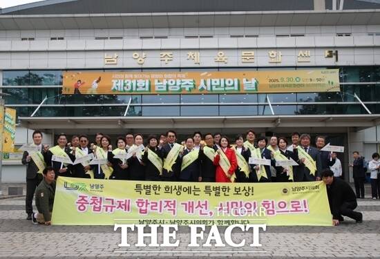 주광덕 남양주시장(앞줄 왼쪽 9번째)과 조성대 남양주시의회 의장(앞줄 왼쪽 8번째)을 비롯한 관계자들이 30일 남양주체육문화센터 실내체육관에서 팔당 상수원 규제 개선 서명운동을 마친 뒤 기념 촬영을 하고 있다. /남양주시