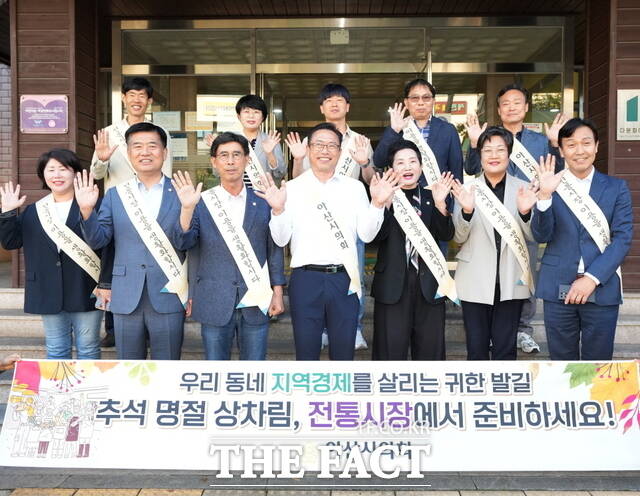 아산시의회 의원들이 온양온천 전통시장에서 추석맞이 장보기 행사에 앞서 단체 사진을 촬영하고 있다. /아산시의회