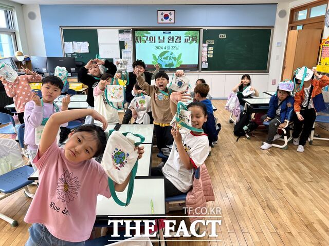 충남도교육청의 지속가능한 미래를 만들어가는 충남미래교육2030 생태·환경교육 진행 중 지구의 날 에코백 만들기를 실시한 아이들이 만든 작품을 들어 보이고 있다. /충남도교육청