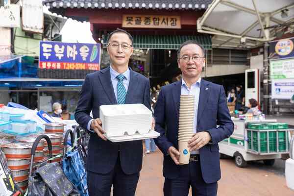 김명규 쿠팡이츠서비스 대표(왼쪽)와 이충환 전국상인연합회 회장이 전통시장 지원 친환경 포장재를 들고 있다. /쿠팡