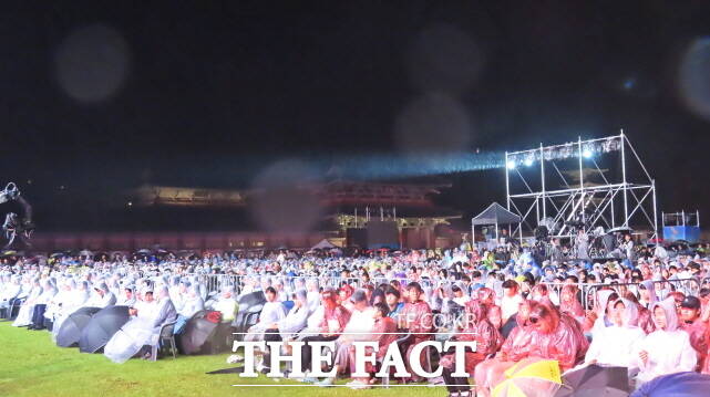 제17회 백제문화제 3일 백제문화단지에서 열린 가운데 비가 오는데도 관광객들이 개막식을 지켜보고 있다. /김형중 기자