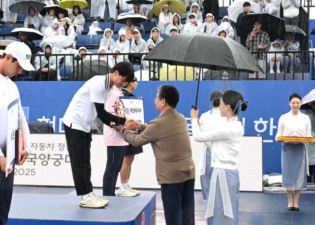 장재훈 현대차그룹 부회장이 3일 광주 동구 5.18 민주광장 특설경기장에서 열린 ‘현대자동차 정몽구배 한국양궁대회 2025’ 남자 리커브 결승전에서 우승을 차지한 김종우 선수에게 우승 트로피를 수여하며 축하하고 있다. ／현대차