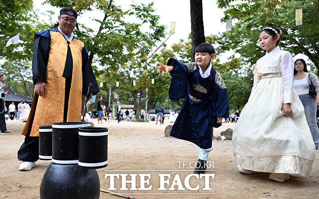 추석 연휴 이틀째인 4일 오후 경기 용인 기흥 한국민속촌을 찾은 한 어린이가 투호놀이를 하며 즐거운 시간을 보내고 있다. /용인=임영무 기자