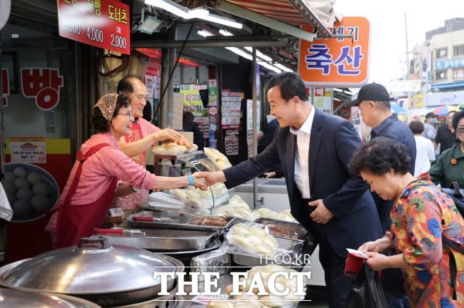 김성제 의왕시장(가운데)이 전통시장에서 장을 보고 있다. /의왕시
