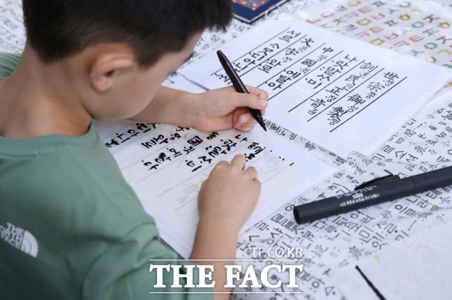 의왕한글한마당에 참가한 어린이가 훈민정음 머릿글을 쓰는 모습. /의왕시