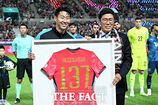 한국 남자 선수 A매치 최다 출전 달성에 성공한 손흥민(왼쪽)이 14일 오후 서울 마포구 서울월드컵경기장에서 열린 Legend Old & New – From Cha, To. Son 특별 행사에서 차범근 전 감독에게 기념 유니폼을 전달 받은 뒤 기념촬영을 하고 있다. /서울월드컵경기장=남용희 기자