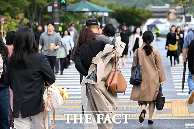 전국 곳곳에 가을비가 내리며 흐린 날씨가 이어지는 14일 오전 서울 종로구 광화문네거리를 지나는 시민이 겉옷을 걸치며 출근길 발걸음을 재촉하고 있다. /서예원 기자