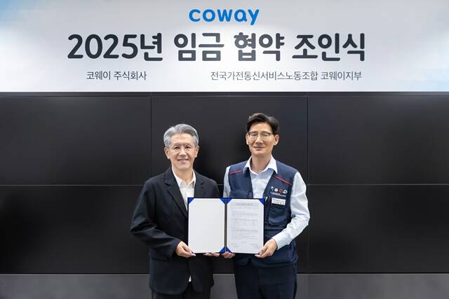 서장원 코웨이 대표이사(왼쪽)와 임창경 코웨이지부 지부장이 지난 13일 2025년 임금 협약을 체결한 뒤 기념 촬영을 하고 있다. /코웨이