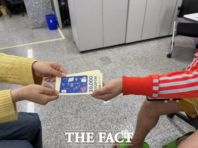 읍면동 담당자가 청년 대상자를 직접 만나 외출 유도형 생활 쿠폰을 전달하고 있다. /아산시