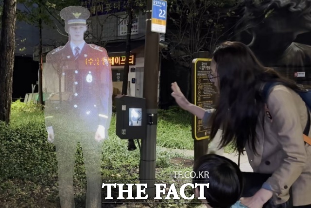 13일 서울 중구 저동 3공원에서 지나가던 시민이 홀로그램 경찰관을 구경하고 있다. /서울 중구=김민지 기자