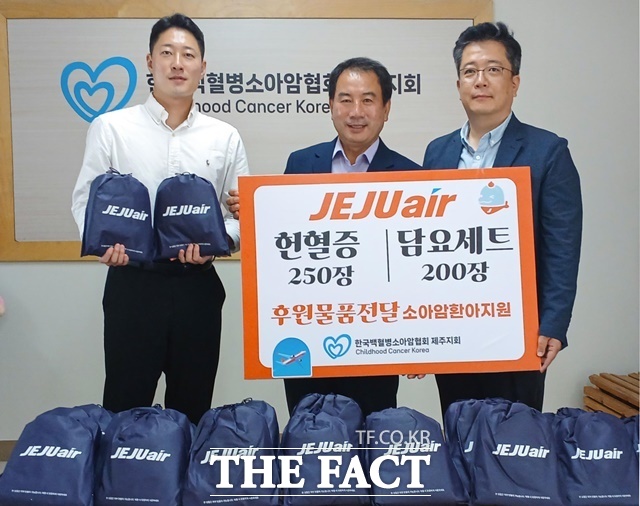 제주항공 김정제 산업안전보건팀장(오른쪽)이 15일 한국백혈병소아암협회 고경남 제주지회장(가운데)에게 헌혈증과 담요 등 여행용 키트를 전달한 뒤 기념 촬영을 하고 있다. /제주항공