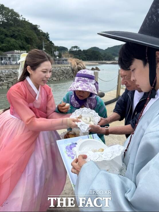 여행 참가자들이 섬 어르신들께 직접 만든 송편과 간식을 나눠드리고 있다. /인천항만공사