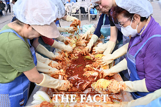 제18회 마포나루 새우젓축제가 17일 오후 서울 마포구 월드컵공원 평화광장 일대에서 열린 가운데 박강수 마포구청장(가운데)이 외국인들과 함께 김치 담그기 체험을 하고 있다. /서예원 기자