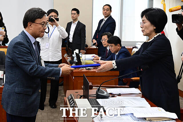 김백 전 YTN 사장(왼쪽)이 최민희 위원장에게 선서문을 제출하고 있다.