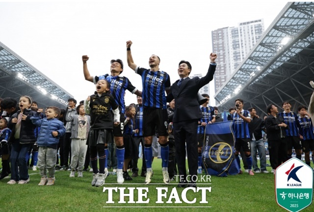 인천 유나이티드를 강등 1년 만에 1부 승격으로 이끈 윤정환 감독(오른쪽)과 선수들이 감격을 나누고 있다./인천=K리그