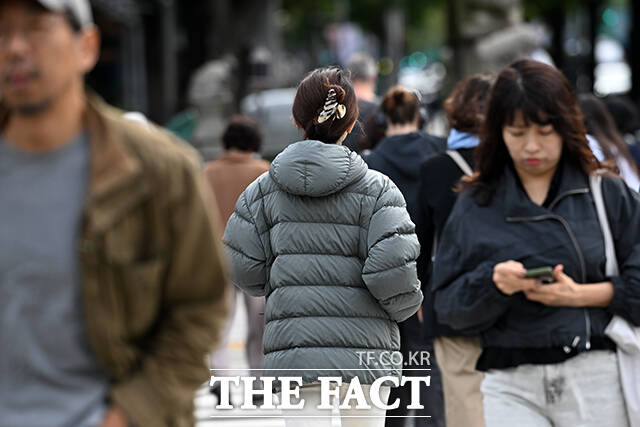 서늘한 출근길에 한 시민이 패딩을 입고 있다.