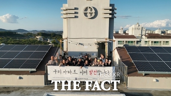 지난 23일 경기 파주시 청석마을 운정동문디이스트 아파트에 모인 아파트 주민들이 옥상에 설치된 태양광 발전설비 옆에서 기념촬영을 하고 있다. /파주시