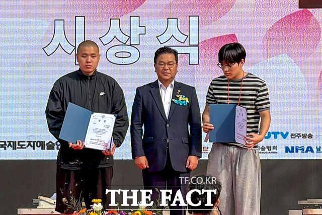 남원시 춘향문화예술회관에서 열린 남원국제도예캠프 시상식에서 목원대 도자디자인과 학생(왼쪽)이 상장을 들고 기념 촬영을 하고 있다. /목원대