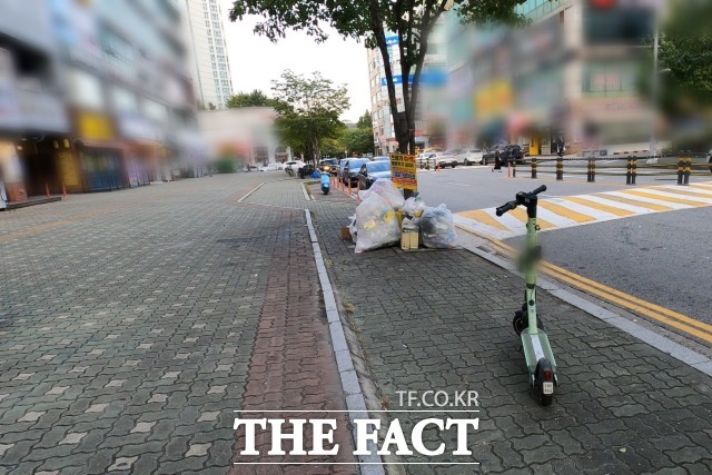 지난 24일 인천 연수구 송도동 한 인도에 전동 킥보드가 주차돼 있다. 6일 전 이곳에서 중학생 두 명이 탄 전동 킥보드가 30대 여성을 치는 사고가 발생했다. /이상빈 기자