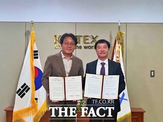 이재율 킨텍스 대표(오른쪽)과 이재철 킨텍스플러스 대표가 지난 27일 ‘모·자회사 자율경영 협약’을 체결한 뒤 협약서를 들어보이고 있다. /킨텍스