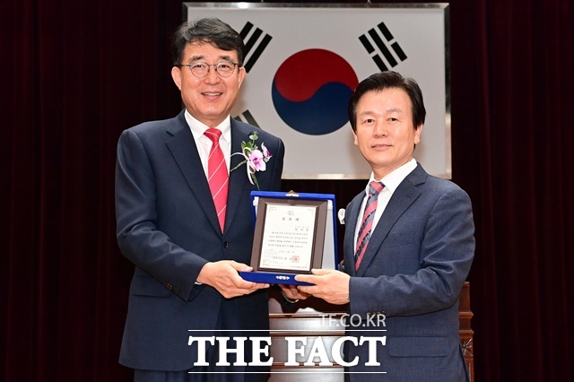 차석호(왼쪽) 진주시 부시장이 31일 명예퇴임식에서 조규일 진주시장으로 부터 공로패를 받고 있다. /진주시