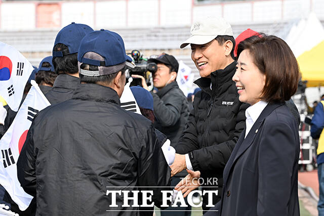 입장하는 어르신들과 악수하는 오세훈 서울시장과 나경원 국민의힘 의원.