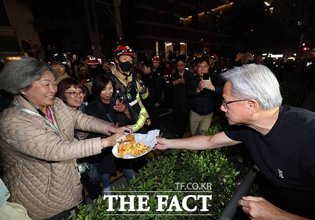 젠슨 황 CEO가 시민들에게 치킨과 감자튀김을 나눠주고 있다. /서예원 기자