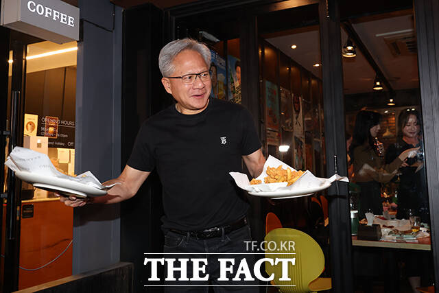 젠슨 황 엔비디아 최고경영자(CEO)가 지난 30일 저녁 서울 삼성동의 한 치킨집에서 이재용 삼성전자 회장, 정의선 현대차그룹 회장과 치맥 회동을 마친 후 취재진 및 시민들에게 치킨을 나눠주고 있다. /서예원 기자