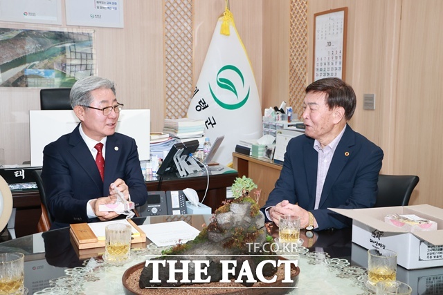 지난 7월 집중호우로 자신의 집이 침수된 황진탁(80) 씨가 오태완(왼쪽) 군수에게 수해 현장에 나선 공무원들에게 감사 떡을 전달하고 환담을 나누고 있다. /의령군