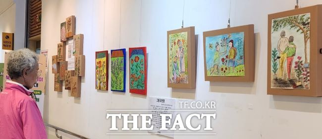 한 노인이 ‘올랑꽃다지전’을 관람하고 있다. /의왕시중앙도서관