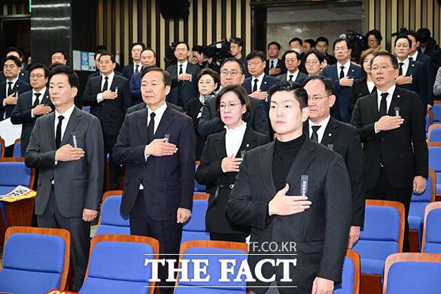 김재섭 의원 등 소속 의원들이 상복에 근조 리본을 달고 국기에 경례하는 모습.
