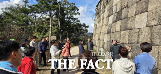 경기 고양시 등이 지난 달 30일 북한산성, 한양도성, 탕춘대성 일대에서 진행한 현장 설명회에서 문화유산 관계자들과 시민들이 신영문 서울시 세계유산등재팀장(오른쪽 3번째)의 한양의 수도성곽에 대한 설명을 경청하고 있다. /고양시