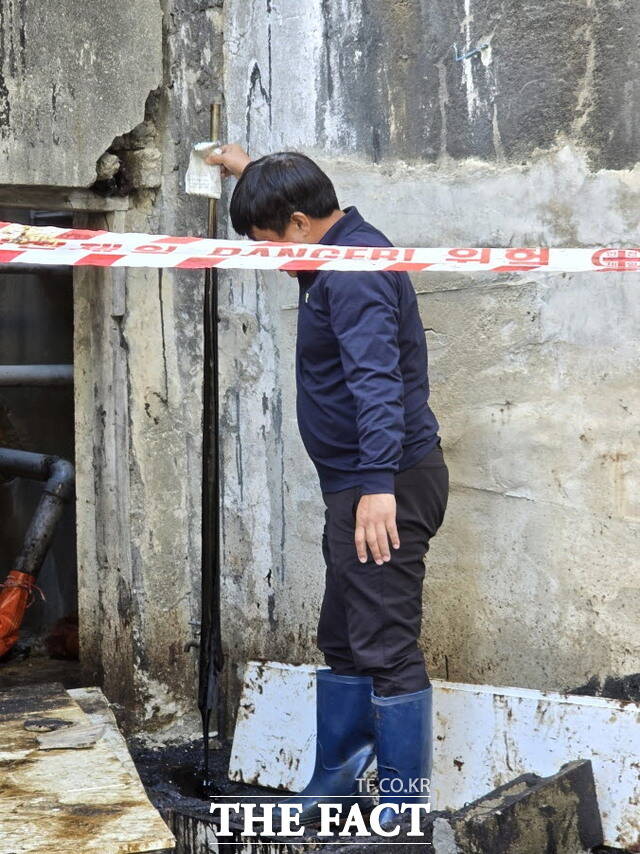 5일 전주시 덕진구 금암동 D아파트와 건산천 상가 인근에서 벙커씨유가 유출돼 전주시를 통해 업체가 처리했는 데도 이날 여전히 유출되고 있다. 한 주민이 긴 막대기로 찐득한 검은 기름을 보여주고 있다. /김은지 기자