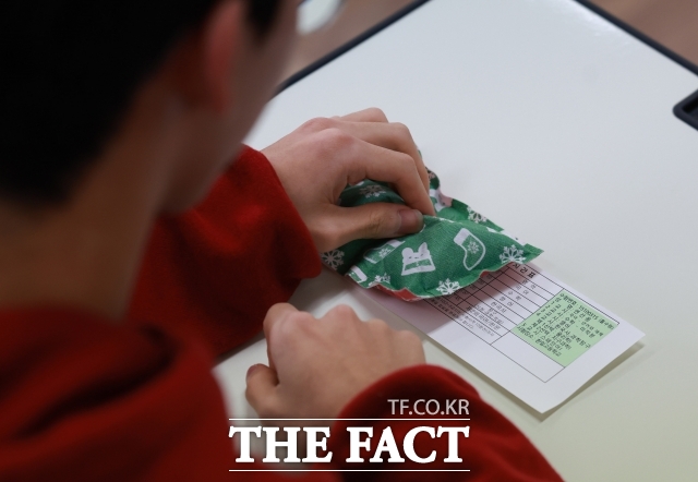 예비소집일 전 사전 교육, 고사장 설치와 점검, 고사장 청소 등도 수능 감독 교사의 몫이다. 사진은 2025학년도 대학수학능력시험 예비소집일인 지난해 11월 13일 서울 종로구 중앙고등학교에서 3학년 학생들이 교사로부터 수험표를 배부받은 뒤 확인하는 모습. /더팩트 DB