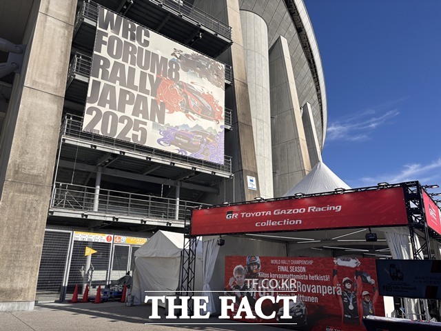 토요타 스타디움 외벽에 내걸린 WRC FORUM8 RALLY JAPAN 2025 대회 현수막. 아래에는 토요타 가주 레이싱 컬렉션 부스가 운영되고 있다. /황지향 기자