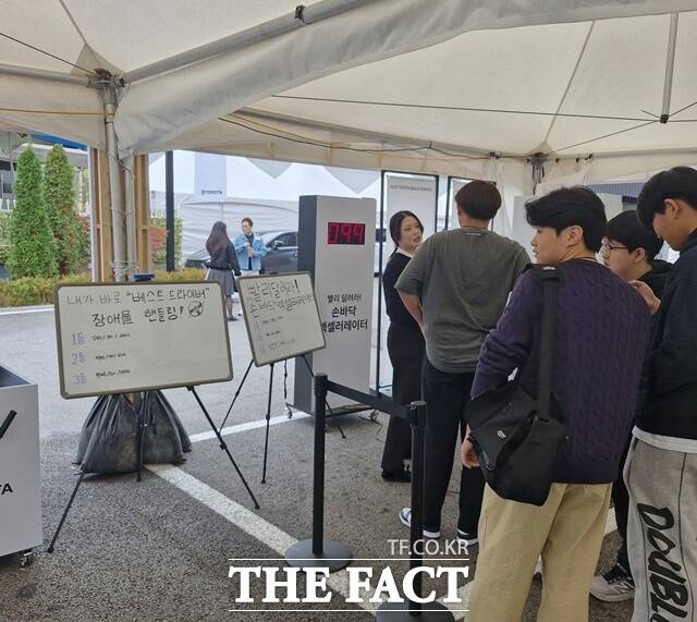 8일 토요타 트레이닝 아카데미 주차장에 마련된 장애물 핸들링, 손바닥 엑셀러레이터 미니 게임에 참여하기 위해 토요타 임직원 및 가족, T-TEP 학생들이 대기하는 모습. /허주열 기자