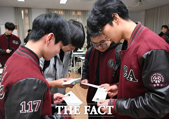 서로의 수험표를 살피며 수능장 확인하는 고3수험생들.