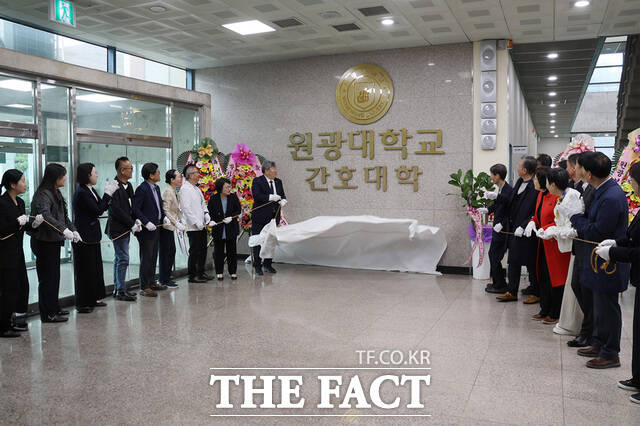 지난 12일 원광대 간호대학에서 열린 간호대학 출범식에서 박성태 원광대 총장과 백준흠 원광보건대 총장, 신은숙 대한간호협회 전북특별자치도간호사회장, 이안생 원광대병원 간호부장, 정석희 전북대 간호대학장, 원광대 간호학과 및 원광보건대 간호학과 교수진 등이 참석한 가운데 현판 제막식 기념 촬영을 하고 있다. /원광대학교