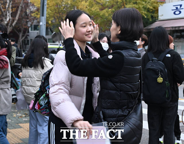 2026학년도 대학수학능력시험일인 13일 오전 서울 광진구 광남고등학교에서 한 수험생이 교문 앞에서 어머니의 응원을 받고 있다. /이새롬 기자