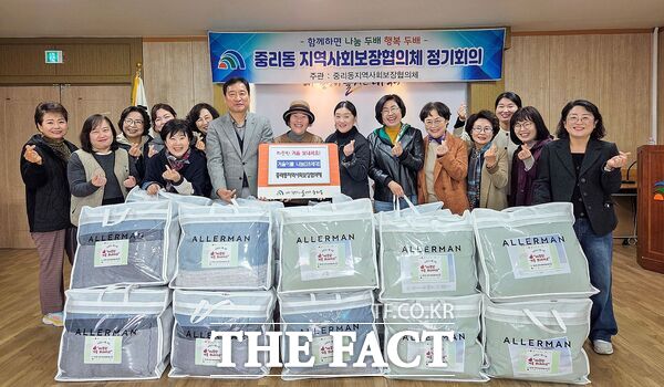 전기원 대덕구 중리동장(사진 왼쪽 일곱 번째)과 중리동 지역사회보장협의체 위원들이 13일 지역의 어려운 이웃을 위한 ‘따뜻한 겨울나기 이불 지원’을 마친 후 기념 촬영을 하고 있다. /대덕구