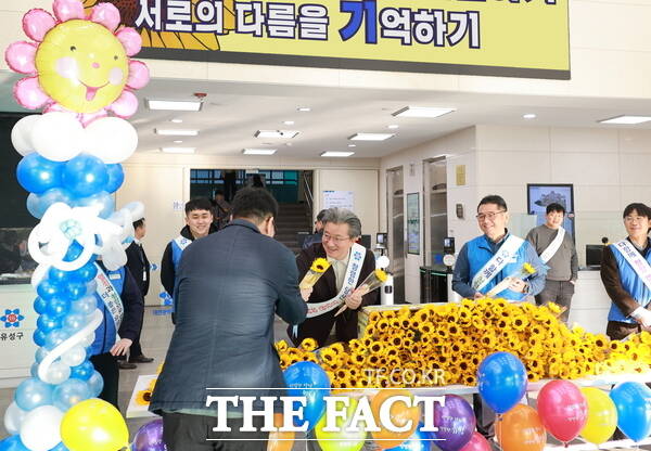 14일 유성구청 본관 로비에서 정용래 유성구청장이 출근하는 직원에게 해바라기꽃을 전달하고 있다. /대전 유성구