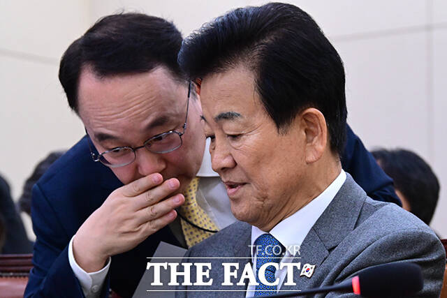 전체회의 앞두고 정동영 통일부 장관(오른쪽)이 관계자와 귀엣말을 나누고 있다.