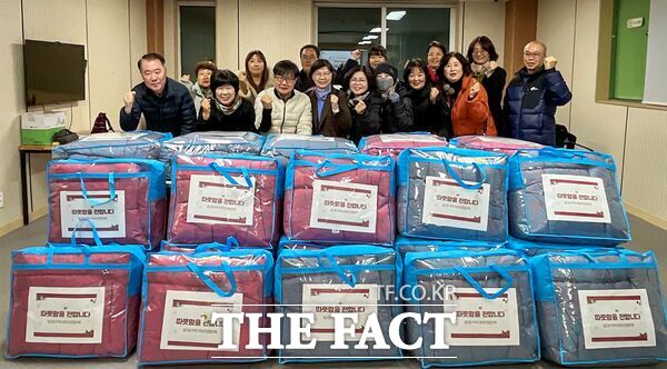 최은호 대덕구 법2동장(사진 첫 번째줄 왼쪽 세 번째)과 18일 지역사회보장협의체 위원들이 난방 취약가구를 위한 겨울이불 나눔사업을 진행하기 앞서 기념 촬영을 하고 있다. /대덕구