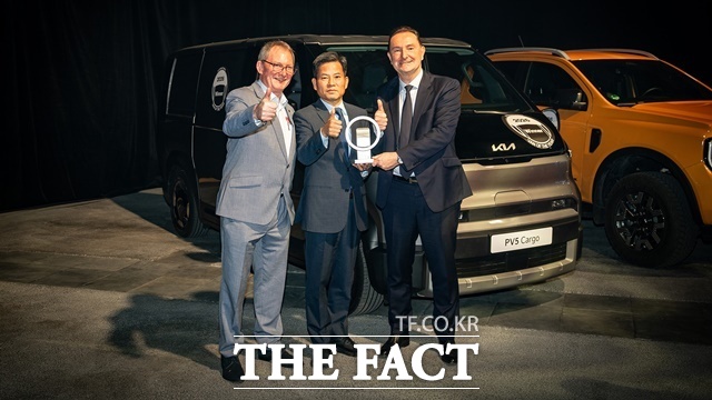 기아 PV5가 19일(현지시각) 프랑스 리옹에서 열린 세계 상용차 박람회 솔루트랜스에서 2026 세계 올해의 밴을 수상했다. (왼쪽부터) IVOTY 잘라스 스위니 위원장, 기아 PBV비즈니스사업부 김상대 부사장, 기아 유럽권역본부장 마크 헤드리히가 기념 촬영하는 모습. /기아