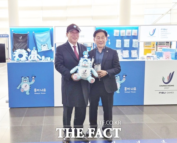 2027 충청 유니버시아드대회 조직위원회가 24일 세종시청 1층 로비에 공식 상품 팝업 부스를 설치하고 20여 종의 굿즈를 선보이는 이벤트를 개최했다. 행사장을 찾은 최민호 세종시장(사진 왼쪽)과 이창섭 조직위 부위원장이 굿즈를 살펴보고 있다. /2027 충청 유니버시아드대회 조직위원회
